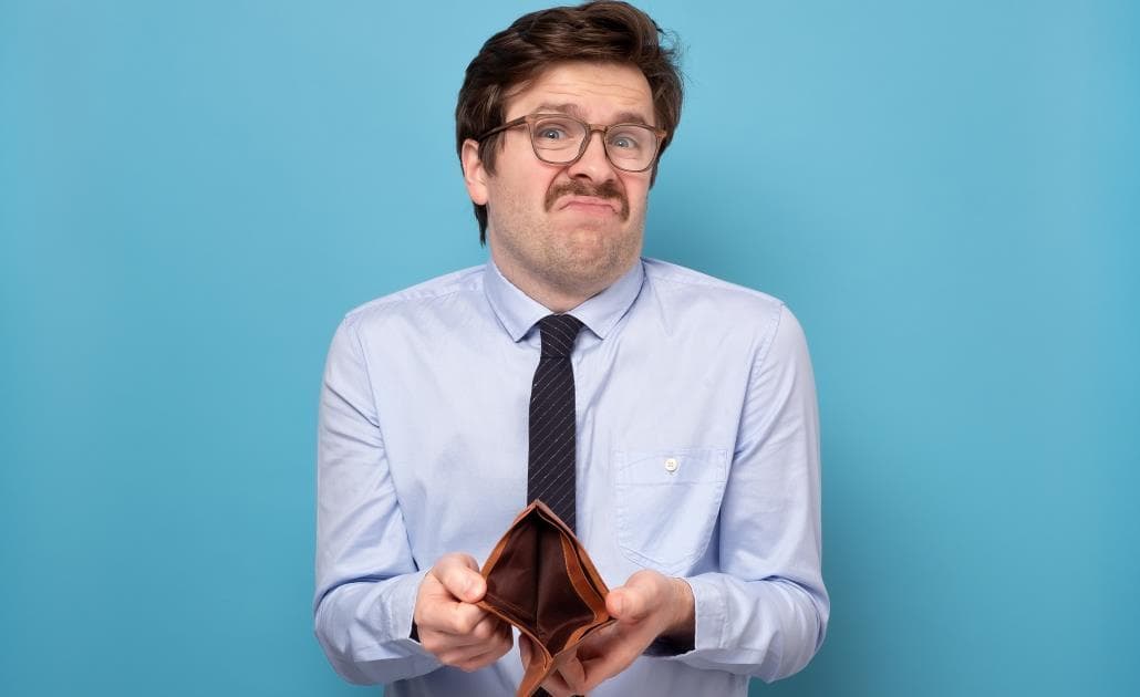 Sad businessmike holding an empty wallet 1030 x 630
