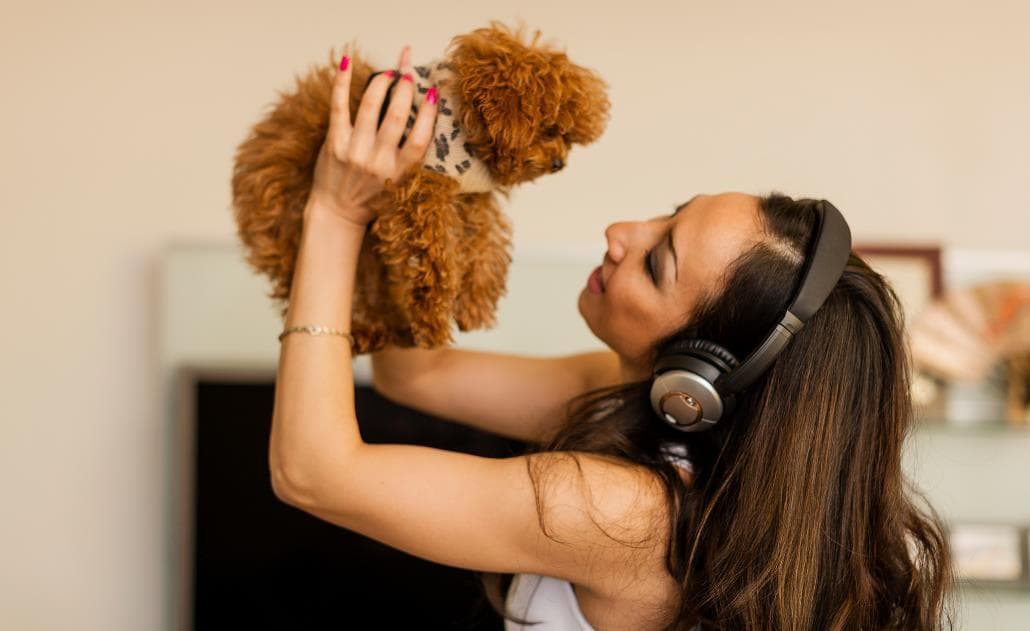 Woman with headphones dancing with dog 1030 x 630